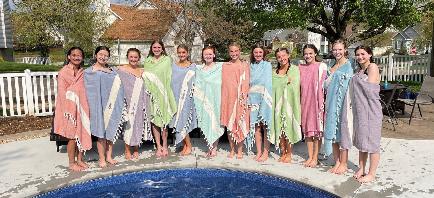Group of friends with matching personalized Turkish towels by the pool