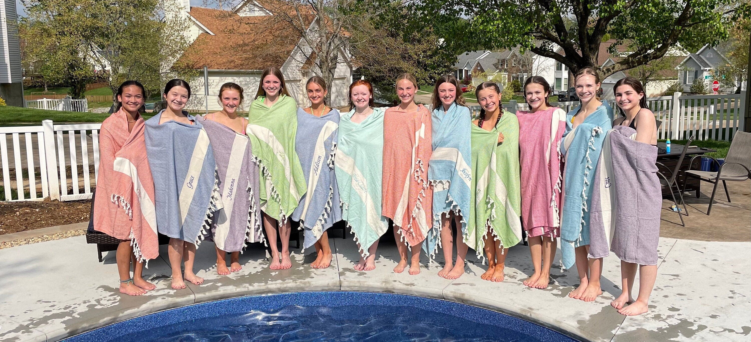 Group of friends with matching personalized Turkish towels by the pool